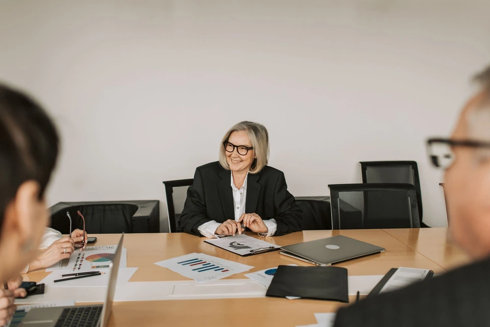 People discussing paperwork in a meeting room.