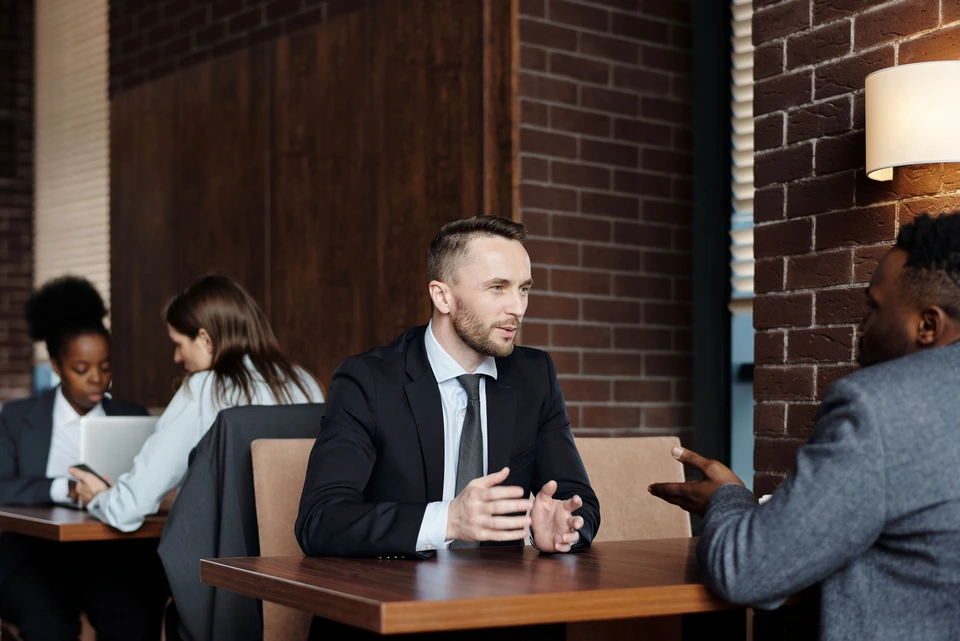 Two people in conversation across a table.